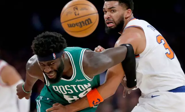 Boston Celtics center Neemias Queta, left, and New York Knicks center Karl-Anthony Towns battle for a loose ball during the first half of an NBA basketball game Thursday, April 9, 2026, in New York. (AP Photo/John Munson)