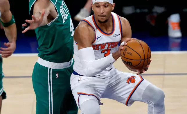 Boston Celtics canter Nikola Vucevic, left, defends against New York Knicks guard Josh Hart, right, during the first half of an NBA basketball game Thursday, April 9, 2026, in New York. (AP Photo/John Munson)