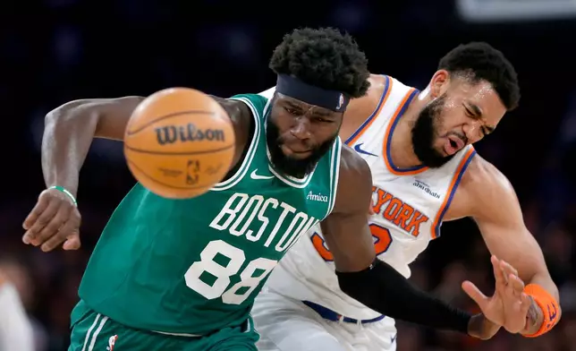 Boston Celtics center Neemias Queta, left, and New York Knicks center Karl-Anthony Towns battle for a loose ball during the first half of an NBA basketball game Thursday, April 9, 2026, in New York. (AP Photo/John Munson)