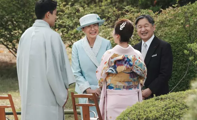 Japan's Emperor Naruhito, right, and Empress Masako, third right, chat with guests, Japanese Olympic figure skating pairs champions Riku Miura, second right, and Ryuichi Kihara during their spring garden party at the Akasaka Palace's imperial garden in Tokyo, Friday, April 17, 2026. (Kazuhiro Nogi/Pool Photo via AP)