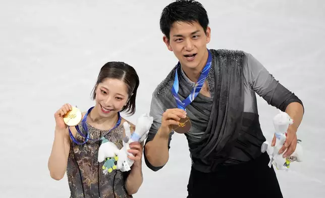 FILE -Gold medalists Riku Miura and Ryuichi Kihara of Japan receive their medals after the pairs figure skating long program at the 2026 Winter Olympics, in Milan, Italy, Monday, Feb. 16, 2026. (AP Photo/Natacha Pisarenko, File)
