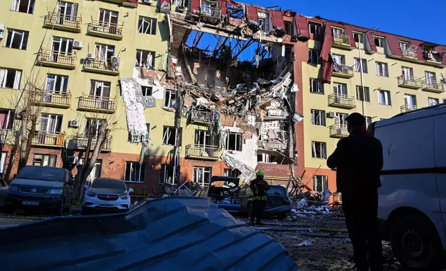 A rescue worker walks in front of residential building which was heavily damaged after a Russian strike in Odesa, Ukraine, Monday, April 6, 2026. (AP Photo/Michael Shtekel)
