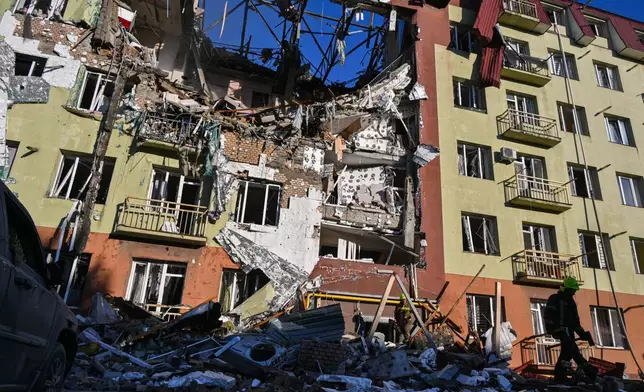 A rescue worker walks in front of residential building which was heavily damaged after a Russian strike in Odesa, Ukraine, Monday, April 6, 2026. (AP Photo/Michael Shtekel)