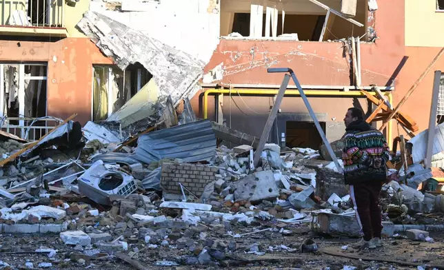 A local man stands in front of residential building which was heavily damaged after a Russian strike in Odesa, Ukraine, Monday, April 6, 2026. (AP Photo/Michael Shtekel)