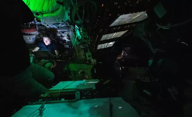 This image provided by NASA, astronaut Christina Koch is illuminated by a screen inside the darkened Orion spacecraft on the third day of the agency's Artemis II mission on Friday, April 3, 2026. (NASA via AP)