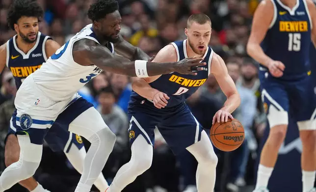 Denver Nuggets guard Christian Braun, center right, collects athee ball as Minnesota Timberwolves forward Julius Randle, front left, defends in the first half in Game 5 of a first-round NBA playoffs basketball series Monday, April 27, 2026, in Denver. (AP Photo/David Zalubowski)