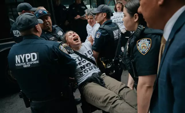Protesters with Jewish Voice for Peace get arrested after blocking traffic during a demonstration outside the New York office of U.S. Sen. Chuck Schumer, calling for an end to the U.S.-Israel war with Iran and opposing U.S. weapons support on Monday, April 13, 2026, in New York. (AP Photo/Andres Kudacki)