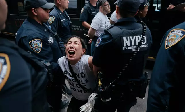 A protester with Jewish Voice for Peace gets arrested after blocking traffic during a demonstration outside the New York office of U.S. Sen. Chuck Schumer, calling for an end to the U.S.-Israel war with Iran and opposing U.S. weapons support, Monday, April 13, 2026, in New York. (AP Photo/Andres Kudacki)