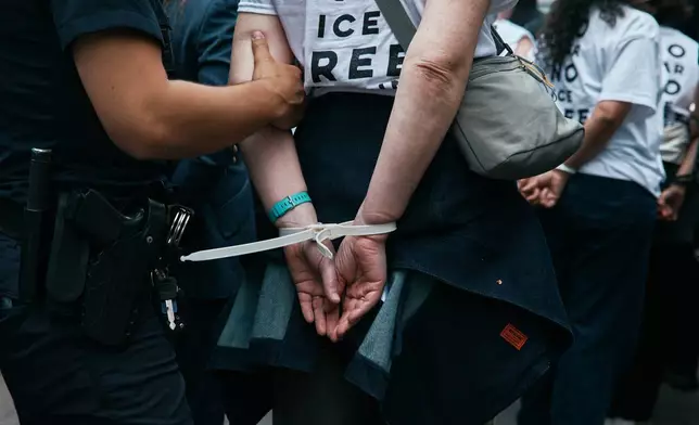 Protesters with Jewish Voice for Peace get arrested after blocking traffic during a demonstration outside the New York office of U.S. Sen. Chuck Schumer, calling for an end to the U.S.-Israel war with Iran and opposing U.S. weapons support, Monday, April 13, 2026, in New York. (AP Photo/Andres Kudacki)