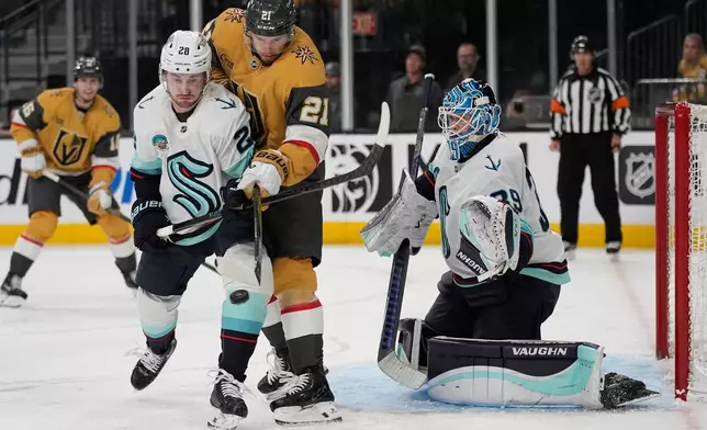 Vegas Golden Knights center Brett Howden (21) attempts to tip is pasy Seattle Kraken goaltender Nikke Kokko (39) during the second period of an NHL hockey game Wednesday, April 15, 2026, in Las Vegas. (AP Photo/John Locher)