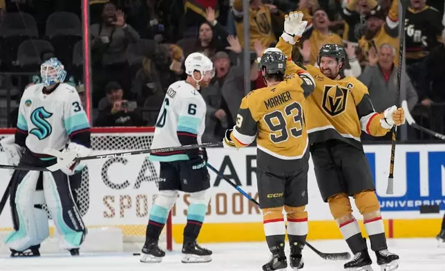 Vegas Golden Knights right wing Mark Stone, right, celebrates after Vegas Golden Knights right wing Mitch Marner (93) scored against the Seattle Kraken during the third period of an NHL hockey game Wednesday, April 15, 2026, in Las Vegas. (AP Photo/John Locher)