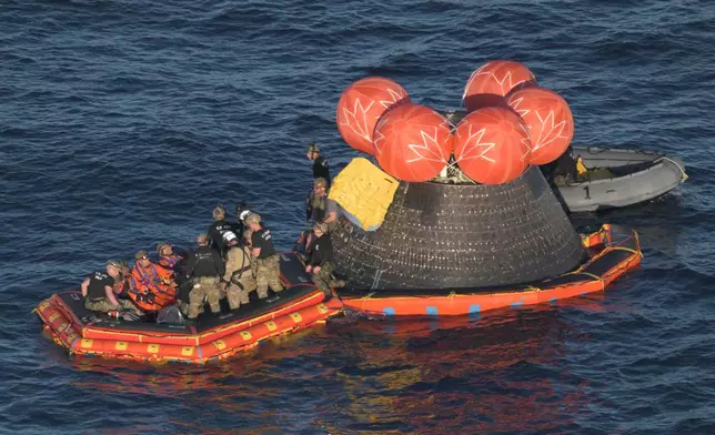 In this photo provided by NASA, Artemis II crew members Cmdr. Reid Wiseman, pilot Victor Glover, mission specialist Christina Koch and Canadian Space Agency mission specialist Jeremy Hansen are loaded into a raft after successfully splashing down in the Pacific Ocean on Friday, April 10, 2026, following their 10-day mission around the Moon. (James Blair/NASA via AP)