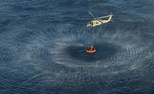 This photo provided by NASA shows the Artemis II crew being hoisted into a U.S. Navy MH-60 helicopter after successfully splashing down in the Pacific Ocean on Friday, April 10, 2026, following their 10-day mission around the Moon. (James Blair/NASA via AP)