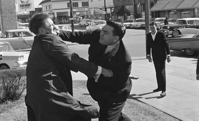 FILE - Alton Wayne Roberts punches CBS cameraman Laurens Pierce outside the Federal Building in Meridian, Miss., Jan. 27, 1965. Roberts, a 26-year-old salesman, was a defendant in the deaths of three civil rights workers. (AP Photo/Jack Thornell, File)