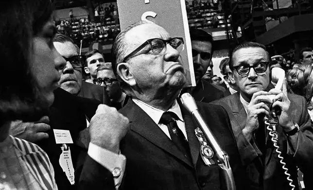 FILE - Mayor Richard J. Daley stands at the microphone as shouts resound through the International Amphitheater in Chicago, demanding the Democratic National Convention adjourn until later in the day before considering the party platform, Aug. 28, 1968. During the convention, hundreds of demonstrators waged war with police and National Guardsmen on the streets of Chicago. (AP Photo/Jack Thornell, File)