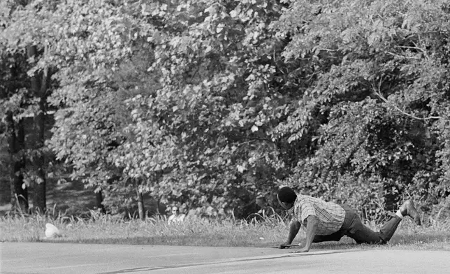 FILE - James Meredith looks at Aubrey James Norvell, background left partially hidden behind foliage, after being shot on a road near Hernando, Miss., June 6, 1966. (AP Photo/Jack Thornell, File)