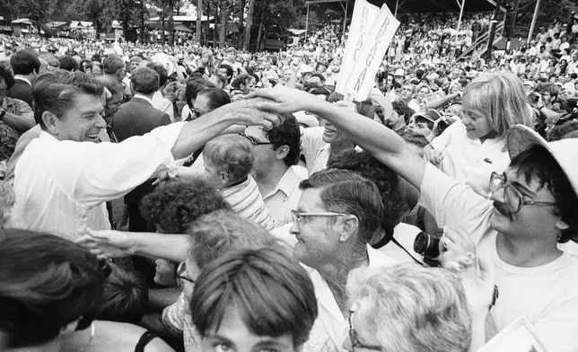 FILE - Republican presidential candidate Ronald Reagan, left, moves through the crowd shaking hands at the Neshoba County Fair in Philadelphia, Mississippi, Aug. 3, 1980. (AP Photo/Jack Thornell, File)