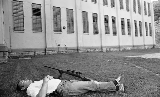 FILE - A sharpshooter at Brushy Mountain State Prison in Petros, Tenn., June 11, 1977, takes a nap on the lawn in front of a cellblock after duty in the search for six escaped convicts, including James Earl Ray. (AP Photo/Jack Thornell, File)