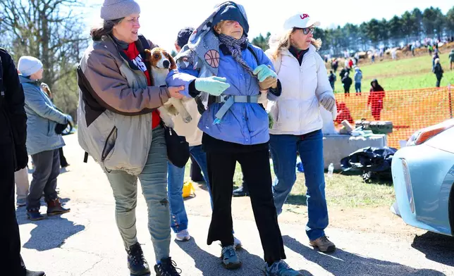 Activists help an elderly woman after she had been tear gassed during an attempt to gain entry into Ridglan Farms beagle breeding and research facility on Saturday, April 18, 2026, in Blue Mounds, Wis. (Owen Ziliak/Wisconsin State Journal via AP)