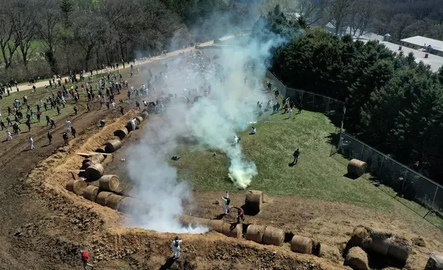 Animal rights activists react to tear gas while attempting to gain entry into Ridglan Farms beagle breeding and research facility in Blue Mounds, Wis., Saturday, April 18, 2026. (Amber Arnold/Wisconsin State Journal via AP)