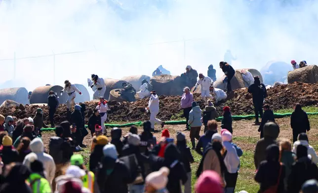 Law enforcement deploy tear gas as activists attempt to gain entry into Ridglan Farms beagle breeding and research facility on Saturday, April 18, 2026, in Blue Mounds, Wis. (Owen Ziliak/Wisconsin State Journal via AP)