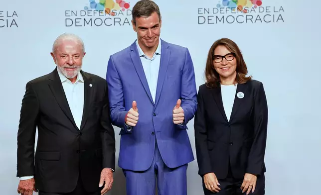 Spain's Prime Minister Pedro Sanchez, center, poses for a photo next to Brazil's President Luiz Inacio Lula da Silva, left, and his wife wife Rosangela Lula da Silva, at the Meeting in Defence of Democracy summit, in Barcelona, Spain, Saturday, April 18, 2026. (AP Photo/Joan Monfort)