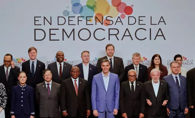 Spain's Prime Minister Pedro Sanchez, center, poses with attendees, at the Meeting in Defence of Democracy summit in Barcelona, Spain, Saturday, April 18, 2026. (AP Photo/Joan Monfort)