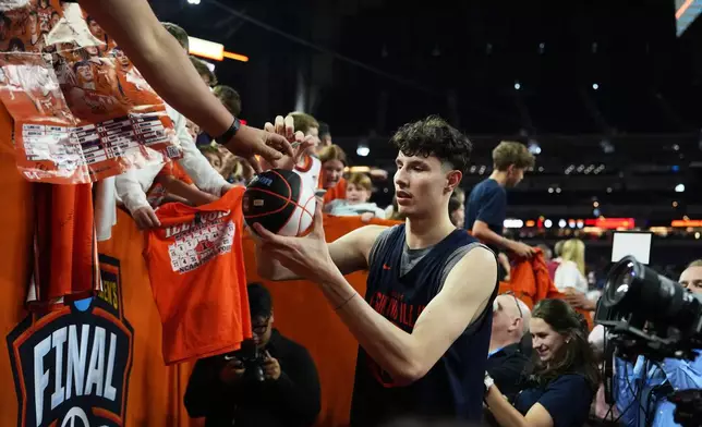 Illinois' Zvonimir Ivisic signs autographs during practice ahead of a national semifinal NCAA college basketball tournament game against UConn at the Final Four, Friday, April 3, 2026, in Indianapolis. (AP Photo/Michael Conroy)