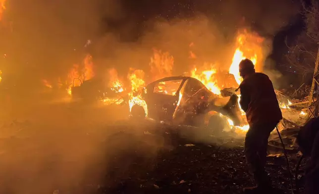 A firefighter extinguishes a car at the site of Israeli airstrikes, in Beirut, Lebanon, Wednesday, April 1, 2026. (AP Photo/Hussein Malla)