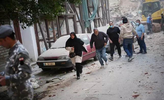 A group of people rushes out of the site of an Israeli airstrike in Beirut, Lebanon, Wednesday, April 8, 2026. (AP Photo/Emilio Morenatti)