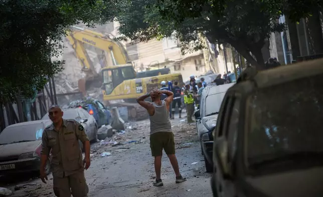 A man reacts as he watches an excavator remove debris at the site of an Israeli airstrike in Beirut, Lebanon, Wednesday, April 8, 2026. (AP Photo/Emilio Morenatti)
