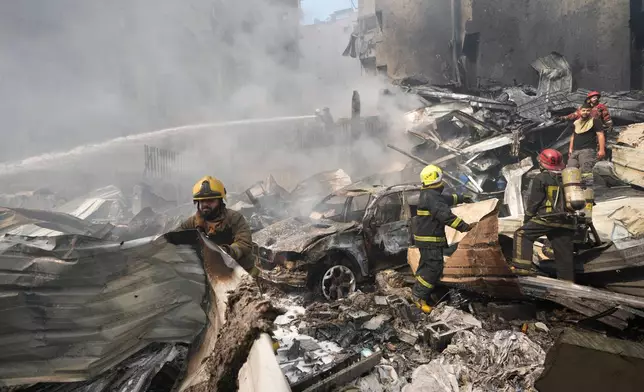 Firefighters gather at the site of an Israeli airstrike in Beirut, Lebanon, Wednesday, April 8, 2026. (AP Photo/Hussein Malla)