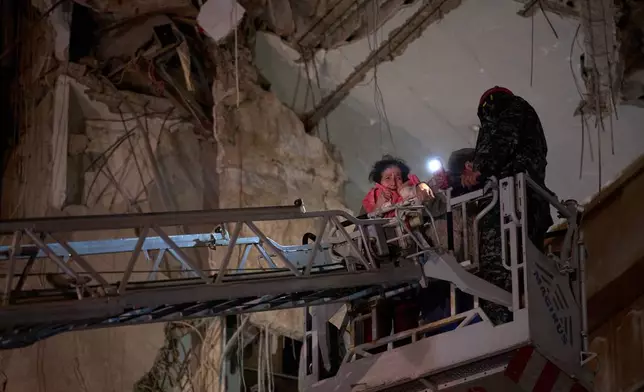 A woman who survived an Israeli airstrike cries as she rescued by a firefighter from a destroyed building in central Beirut, Lebanon, Wednesday, April 8, 2026. (AP Photo/Emilio Morenatti)