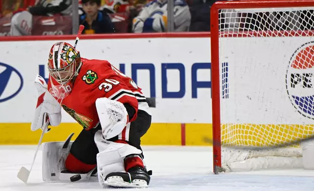 Chicago Blackhawks goalie Spencer Knight makes a save during the first period of an NHL hockey game against the Buffalo Sabres in Chicago, Monday, April 13, 2026. (AP Photo/Paul Beaty)