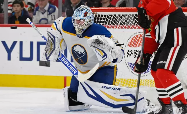 Buffalo Sabres goalie Ukko-Pekka Luukkonen, left, makes a save during the second period of an NHL hockey game against the Chicago Blackhawks in Chicago, Monday, April 13, 2026. (AP Photo/Paul Beaty)