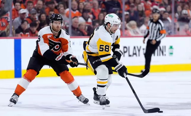 Pittsburgh Penguins' Kris Letang, right, tries to get past Philadelphia Flyers' Cam York during the first period of Game 4 in the first round of the NHL Stanley Cup hockey playoffs Saturday, April 25, 2026, in Philadelphia. (AP Photo/Matt Slocum)