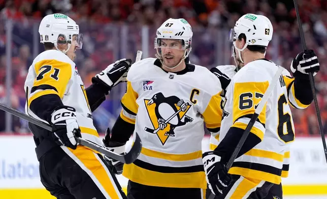 Pittsburgh Penguins' Sidney Crosby, center, celebrates with Evgeni Malkin, left, and Rickard Rakell after scoring during the first period of Game 4 against the Philadelphia Flyers in the first round of the NHL Stanley Cup hockey playoff series Saturday, April 25, 2026, in Philadelphia. (AP Photo/Matt Slocum)