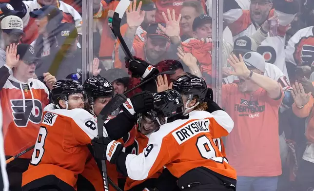 Philadelphia Flyers' Denver Barkey, center, celebrates with teammates after scoring during the second period of Game 4 against the Pittsburgh Penguins in the first round of the NHL Stanley Cup hockey playoff series Saturday, April 25, 2026, in Philadelphia. (AP Photo/Matt Slocum)