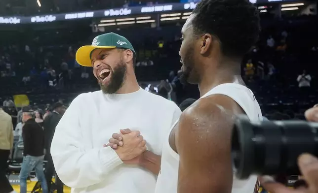 Golden State Warriors guard Stephen Curry, left, smiles while shaking hands with Cleveland Cavaliers guard Donovan Mitchell after an NBA basketball game in San Francisco, Thursday, April 2, 2026. (AP Photo/Jeff Chiu)