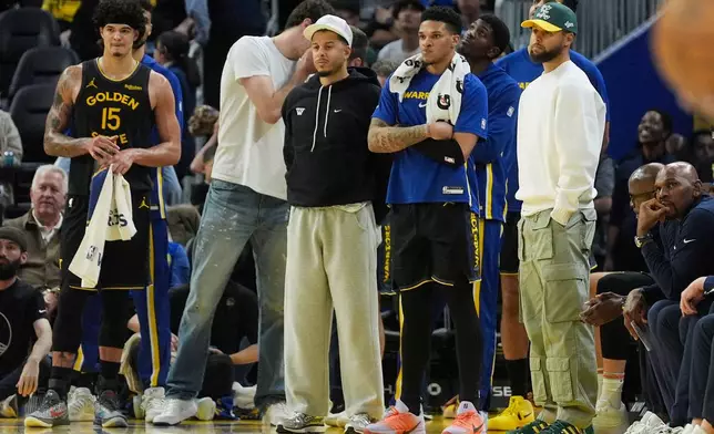 Golden State Warriors forward Gui Santos, from left, reacts from the sideline with Quinten Post, Seth Curry, Will Richard and Stephen Curry during the second half of an NBA basketball game against the Cleveland Cavaliers in San Francisco, Thursday, April 2, 2026. (AP Photo/Jeff Chiu)