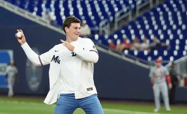 Indiana quarterback Fernando Mendoza throws out the ceremonial first pitch at the start of a baseball game between the Miami Marlins and the St. Louis Cardinals, Tuesday, April 21, 2026, in Miami. (AP Photo/Rebecca Blackwell)