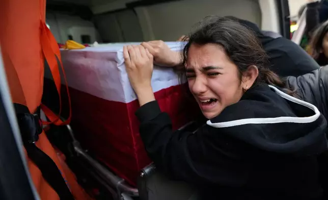 A girl mourns over the coffin of a relative who was killed in the war between Hezbollah and Israel during a mass funeral in Bazouriyeh village, south Lebanon, Monday, April 20, 2026. (AP Photo/Mohammed Zaatari)