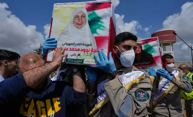 Mourners and scouts carry the coffins of civilians who were killed in the war between Hezbollah and Israel during a mass funeral in Bazouriyeh village, south Lebanon, Monday, April 20, 2026. (AP Photo/Mohammed Zaatari)