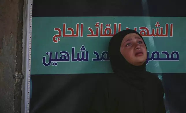 A girl mourns during a mass funeral procession for Hezbollah fighters killed before the ceasefire in the war between Hezbollah and Israel in the southern village of Kfar Sir, Lebanon, Tuesday, April 21, 2026. (AP Photo/Hassan Ammar)
