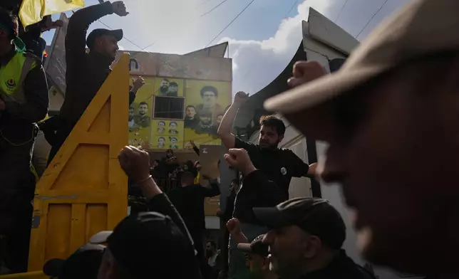 Mourners raise their fists during the funeral procession for Hezbollah fighters killed before the ceasefire in the war with Israel, in Kfar Sir, southern Lebanon, Tuesday, April 21, 2026. (AP Photo/Hassan Ammar)