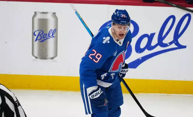 Colorado Avalanche center Nathan MacKinnon reacts after scoring his 50th goal of the season in the first period of an NHL hockey game against the Vancouver Canucks Wednesday, April 1, 2026, in Denver. (AP Photo/David Zalubowski)