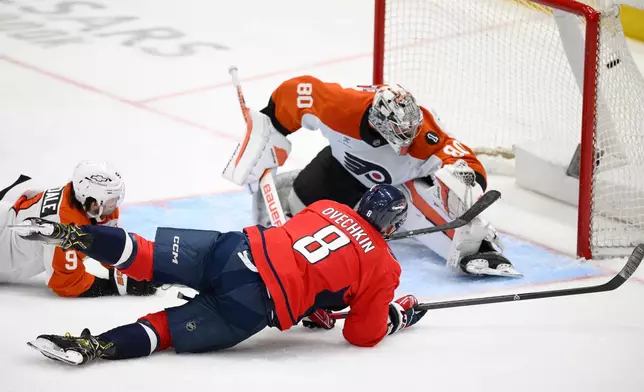 Washington Capitals left wing Alex Ovechkin (8) scores a goal past Philadelphia Flyers goaltender Dan Vladar (80) and defenseman Jamie Drysdale (9) during the third period of an NHL hockey game, Tuesday, March 31, 2026, in Washington. (AP Photo/Nick Wass)