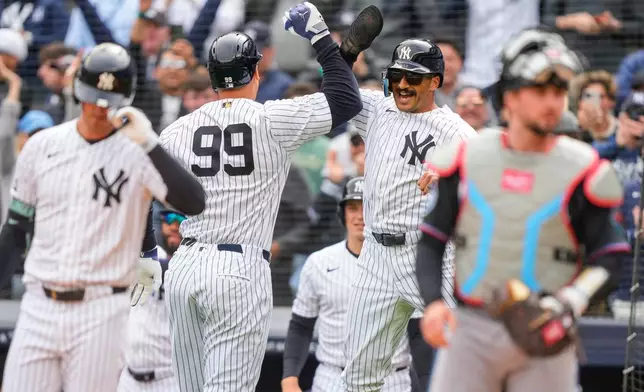 New York Yankees' Aaron Judge (99) celebrates with Trent Grisham (12) after hitting a two-run home run during the first inning of the Yankees' home-opener baseball game against the Miami Marlins, Friday, April 3, 2026, in New York. (AP Photo/Yuki Iwamura)