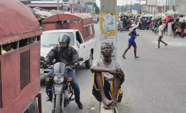 A man sleeps on a lane divider in the Delmas neighborhood of Port-au-Prince, Haiti, Thursday, April 9, 2026. (AP Photo/Odelyn Joseph)