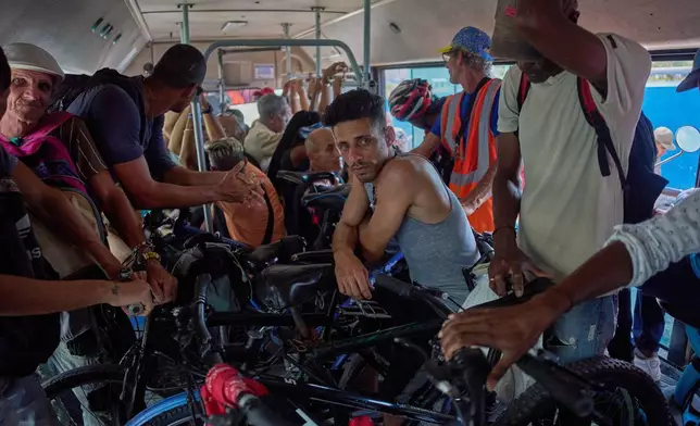 People with their bicycles and motorcycles cross the Bay Tunnel in a public bus in Havana, Wednesday, April 8, 2026. (AP Photo/Ramon Espinosa)